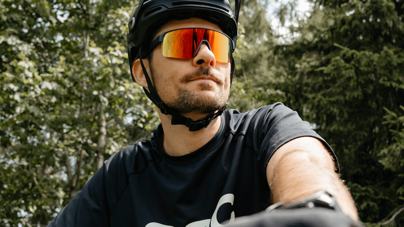 Junger Herr mit Sportbrille auf Fahrrad