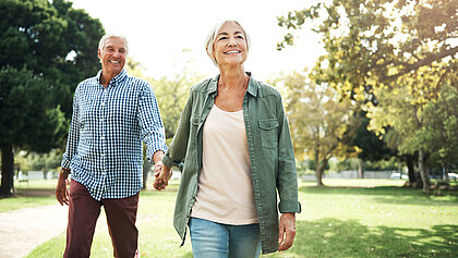 Eine ältere Dame und Herr gehen Hand in Hand