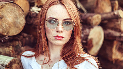 Portrait einer rothaarigen Dame mit Sonnenbrille