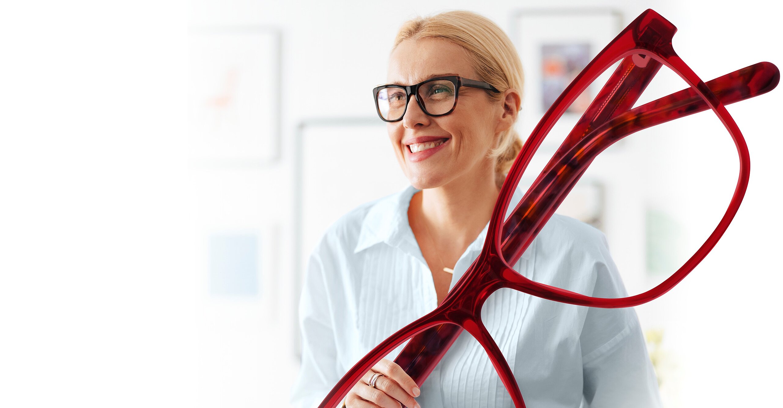 Ältere Dame mit Brille hält eine große rote Brille