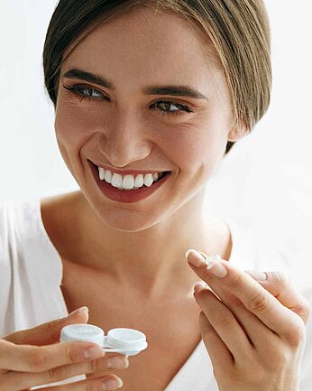 Eine Frau mit Kontaktlinsenbehälter in der Hand