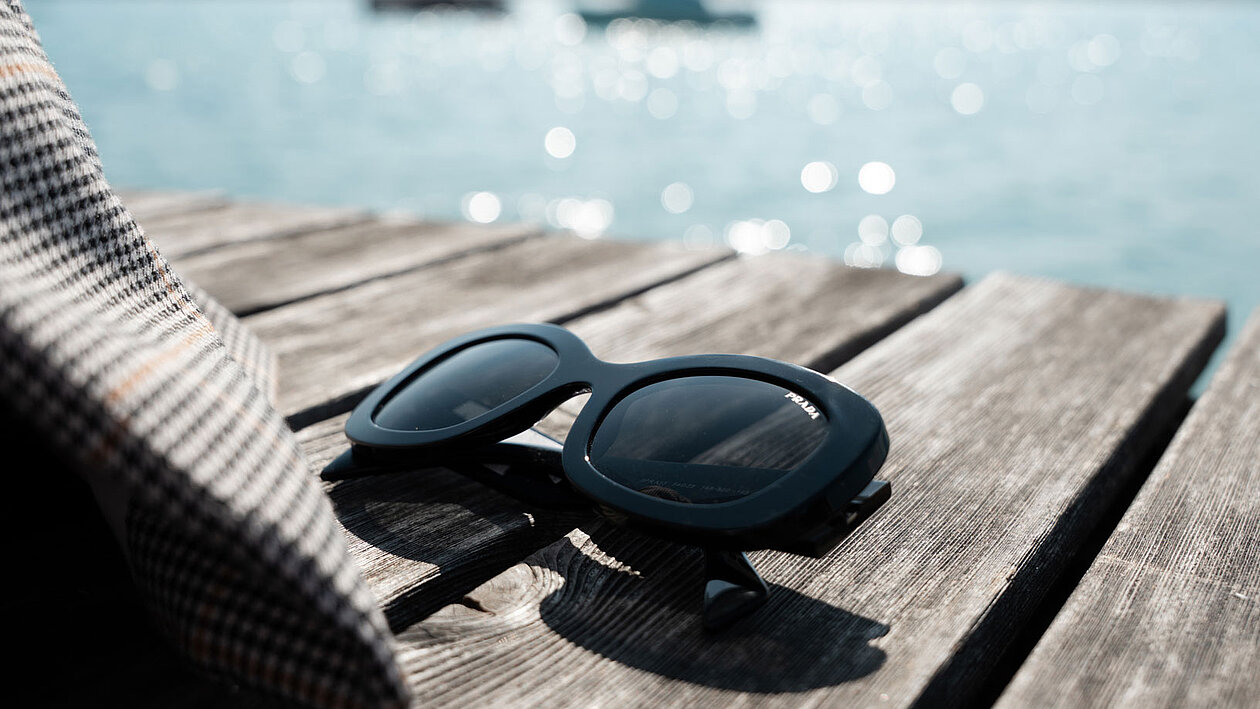 Nahaufnahme einer UV Schutz Sonnenbrille auf einem Steg