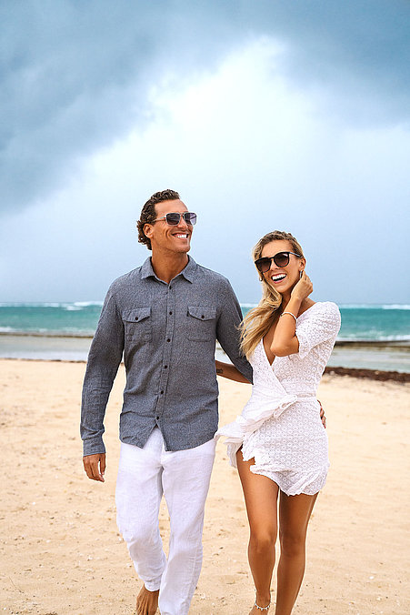 Eine Frau und ein Mann mit Sonnenbrillen am Strand