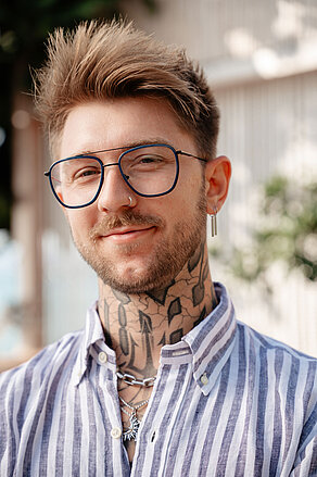 Junger Herr mit Pilotenbrille im Freien