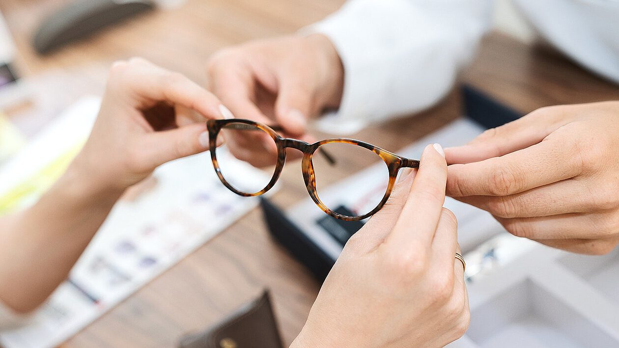 Eine Dame hält eine Brille